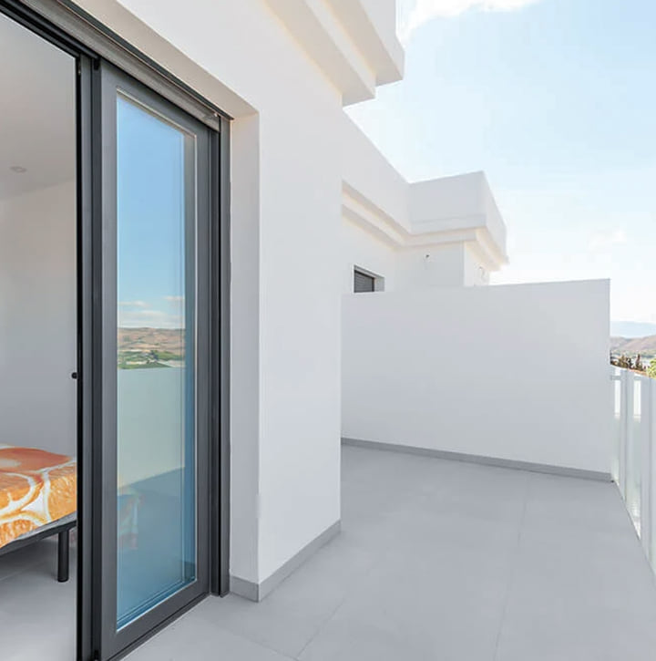 Baie coulissante en aluminium anthracite avec coffre tunnel intégré, ouvrant sur un balcon de villa à Cap Spartel — réalisation Aluminium Tanger