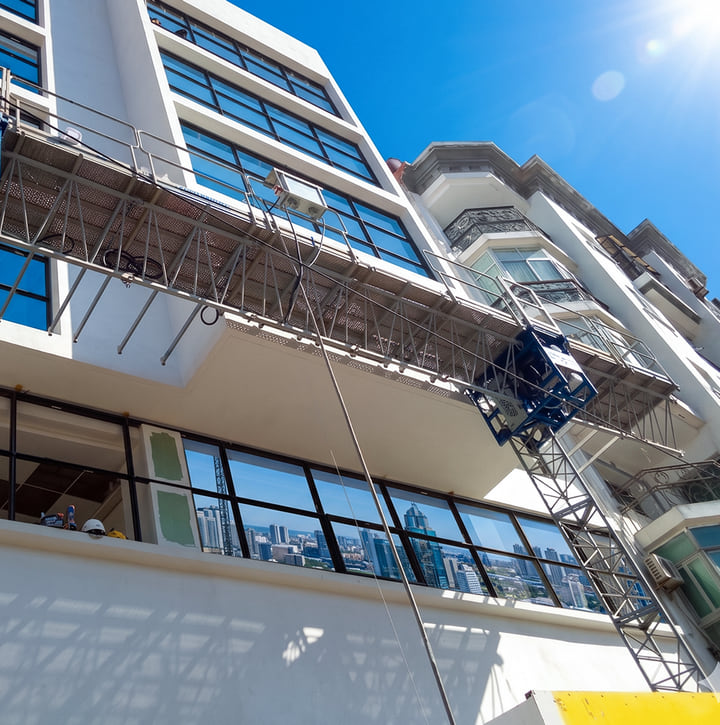 Pose de fenêtres aluminium sur une façade d'immeuble en hauteur depuis une nacelle de chantier à Tanger — Aluminium Tanger