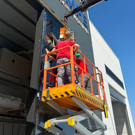 Techniciens posant un vitrage de mur-rideau à la ventouse depuis une nacelle sur une façade à Tanger — Aluminium Tanger