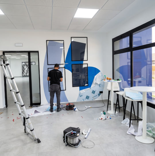 Pose de signalétique publicitaire et habillage mural en vinyle dans un bureau à Tanger — WeAlu